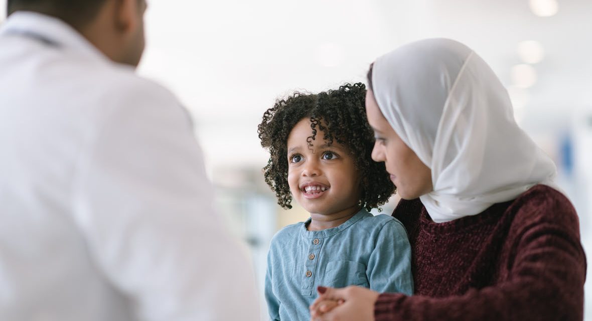 Racially diverse mother and child talking to a provider
