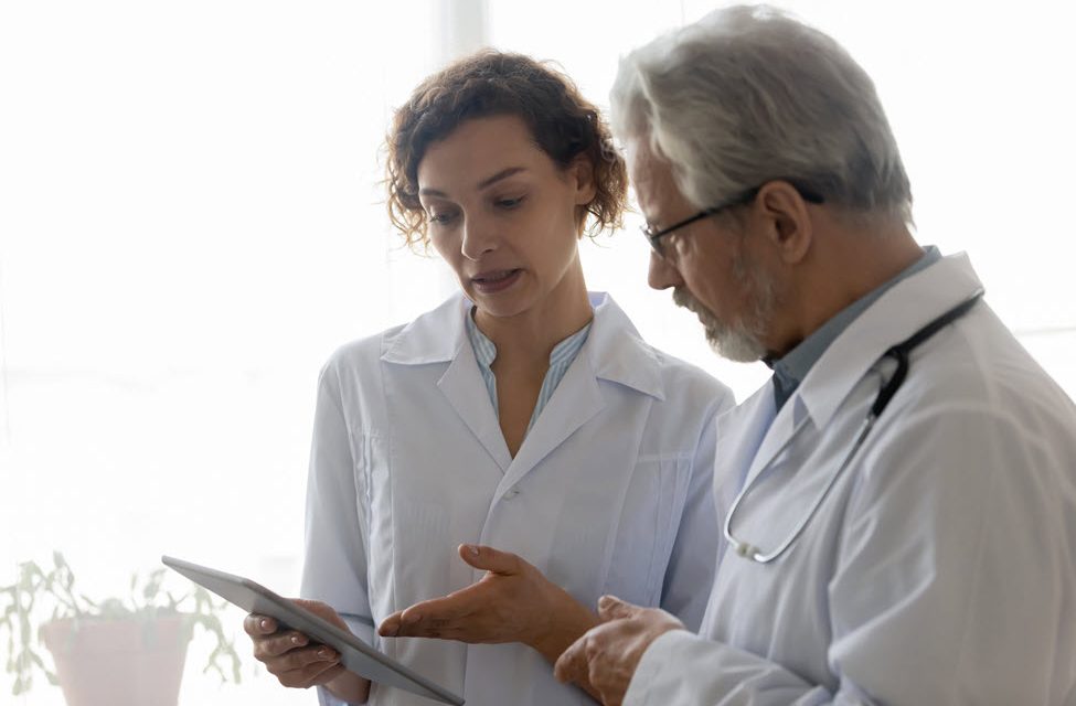 Male and female providers looking at tablet screen